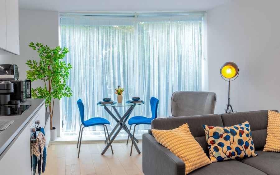 Open-plan kitchen, dining and living area with a grey sofa