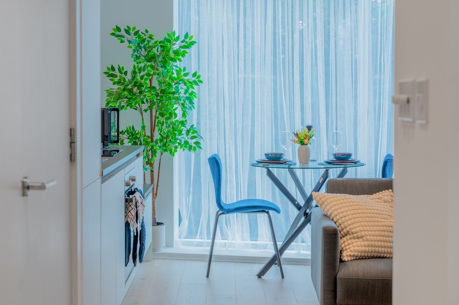 Dining corner with blue chairs, seen from the kitchen