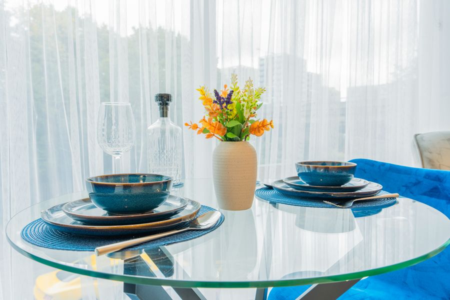 Table set with blue bowls and flowers by the window