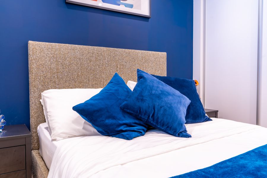 Close view of the bed with blue velvet cushions