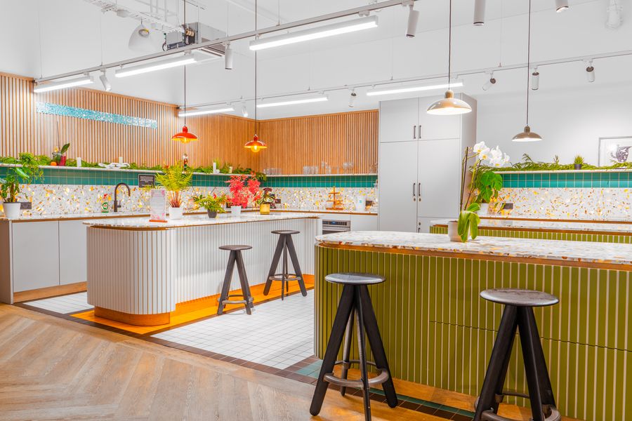 Shared kitchen with terrazzo islands and wooden slatted walls