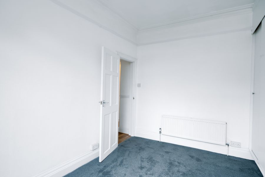 Bedroom with grey carpet and a radiator