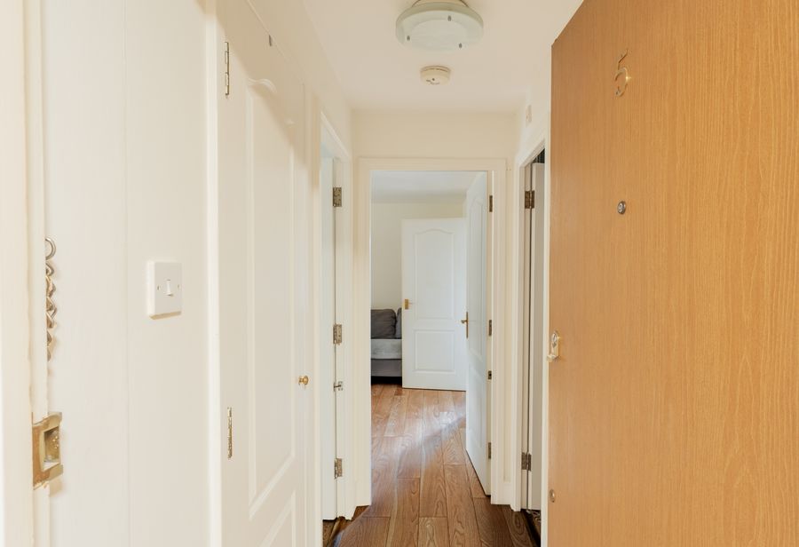 Hallway with a wooden floor and white doors